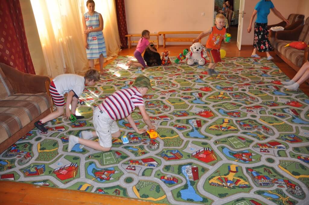 Дети из приюта на развивающем ковре паласе